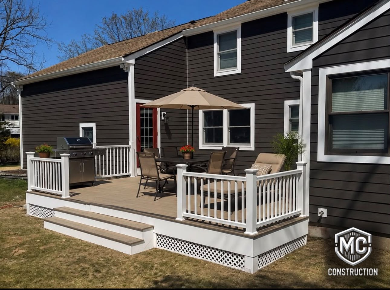 New composite deck with white vinyl railings built by MC Construction and Improvement